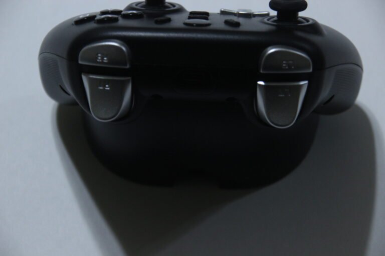 Close-up of a black game controller viewed from above, showing triggers and shoulder buttons.